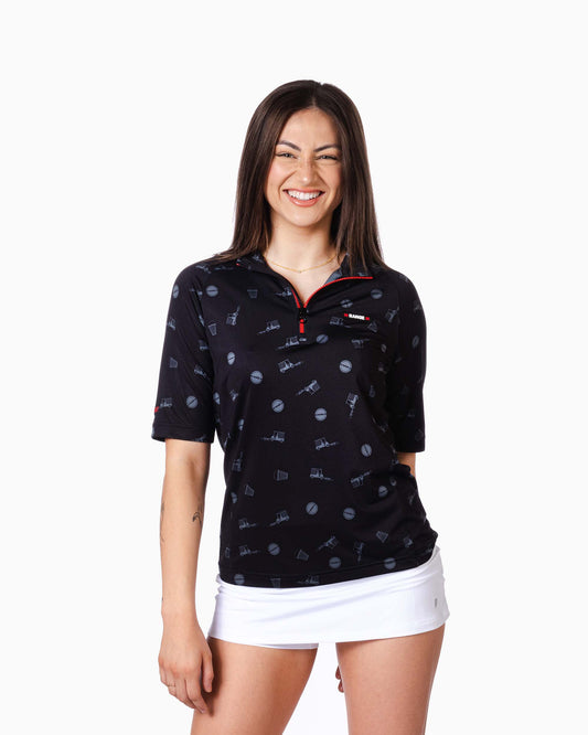 woman wearing range polo with range badge on pocket and scattered golf designs 